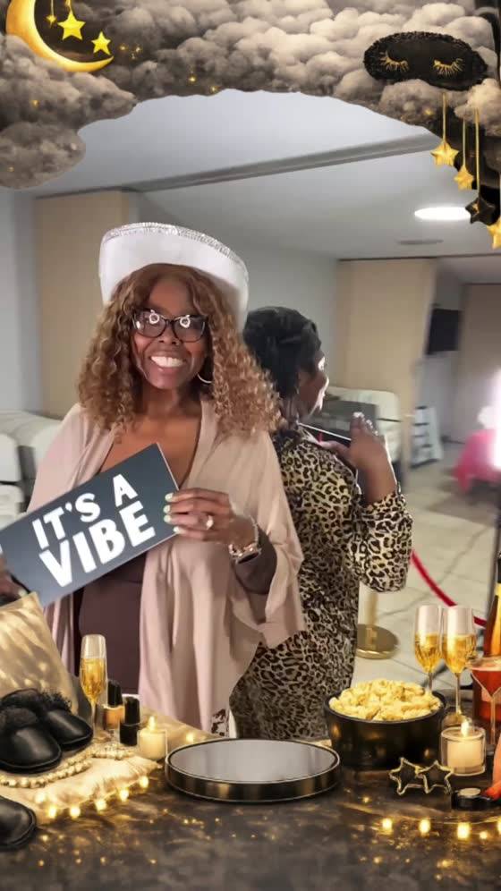 Guest holding an It’s A Vibe sign