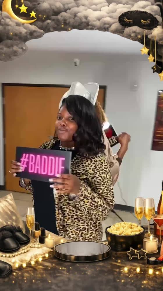 Guest holding a #BADDIE prop sign